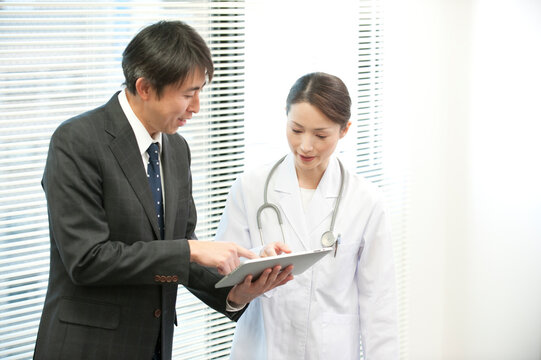 病院でタブレットPCで情報提供するＭＲと女医