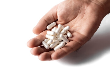 A man's hand holds pills. Capsules are white. Medicines. Isolate on a white background.