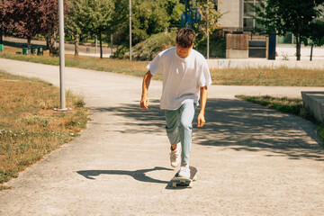 young teenager boy on the street skating with skateboard