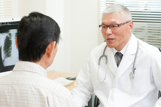 老人患者を診察する中高年の医師