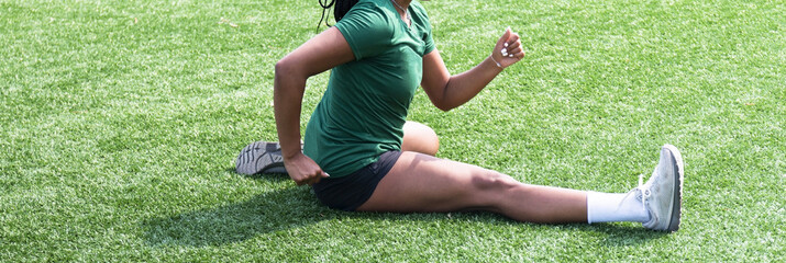 Athletic women stretching on a green turf field