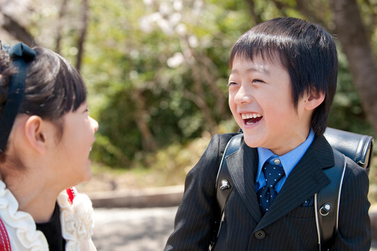 桜と新入学のランドセルの小学生男女