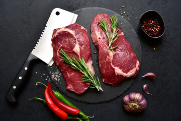 Raw organic rib eye steak with ingredients for making. Top view with copy space.