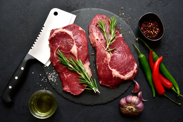 Raw organic rib eye steak with ingredients for making. Top view with copy space.