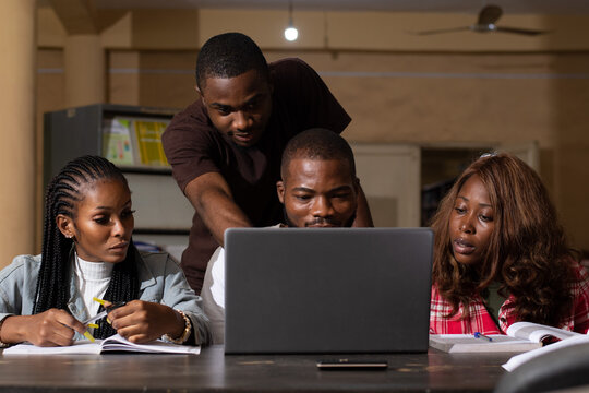 a group of black students studying using a laptop