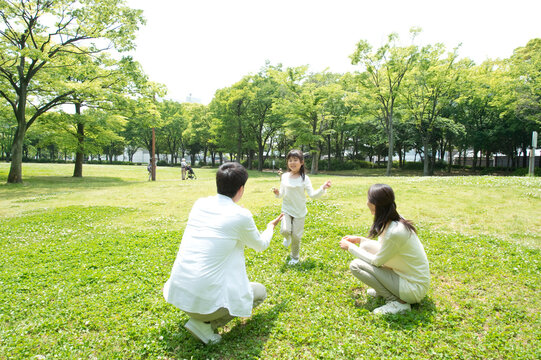 公園で遊ぶ三人家族