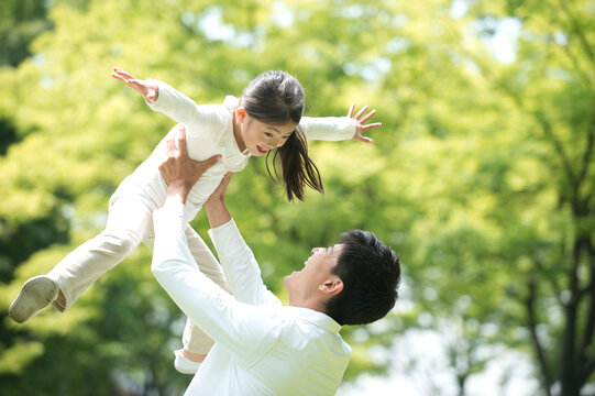 公園で女の子を抱き上げる父