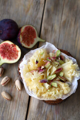 Tete de Moine cheese with figs on a wooden background. Cheese snacks.