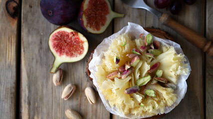 Tete de Moine cheese with figs on a wooden background. Cheese snacks.