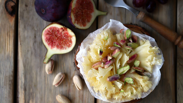 Tete de Moine cheese with figs on a wooden background. Cheese snacks.