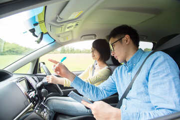 車を運転する若い女性と教習所教官