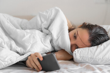 Young woman goes to sleep Phone addiction, insomnia. try to fall asleep. Sleep tracking on the...