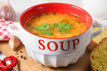 kharcho soup with greens in a white and red plate
