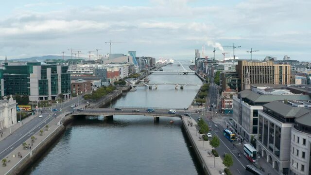 Forwards fly above Liffey river flowing through city. Multiple bridges connecting embankments. Dublin, Ireland