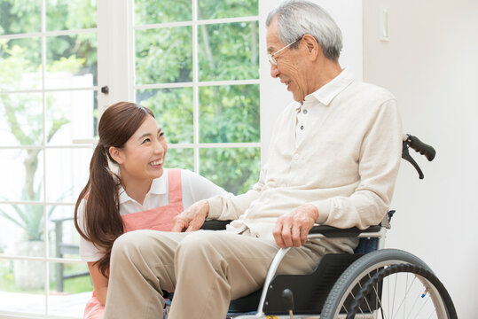 介護士女性と車椅子のシニア男性