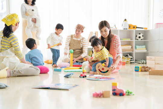保育園で遊ぶ園児と保育士