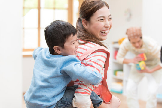 男の子をおんぶする女性介護士