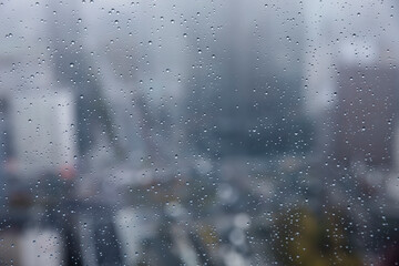 Water droplets in a close up on a high office building with city landscape in the background