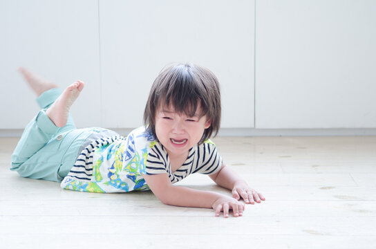 床に這いつくばって泣いている男の子