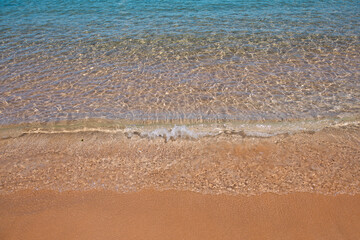 Beach with golden sand, turquoise ocean water. Panoramic sea view. Natural background for summer vacation.