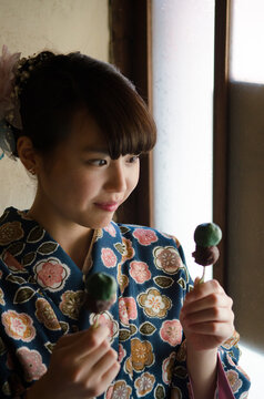 お団子を見つめる着物姿の女性