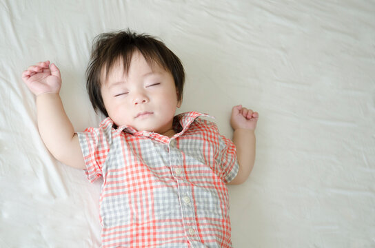 シーツの上でで眠る男の子