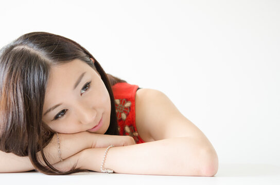 机の上に腕を組み顔を乗せる女性