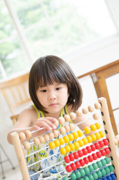 100玉そろばんで遊んでいる女の子