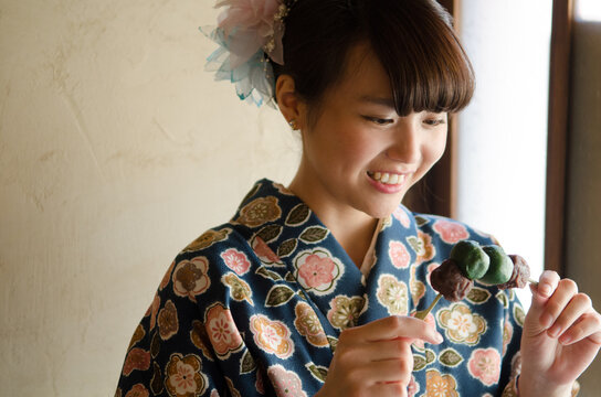 お団子を見つめる着物姿の女性