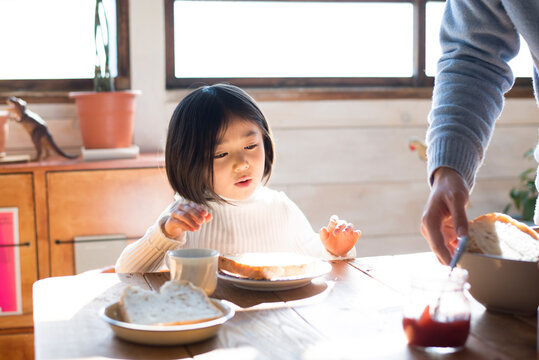 食卓にいる女の子とお父さんの手