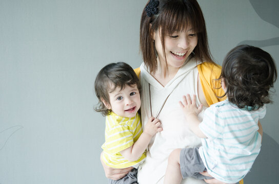 双子を抱っこする女性