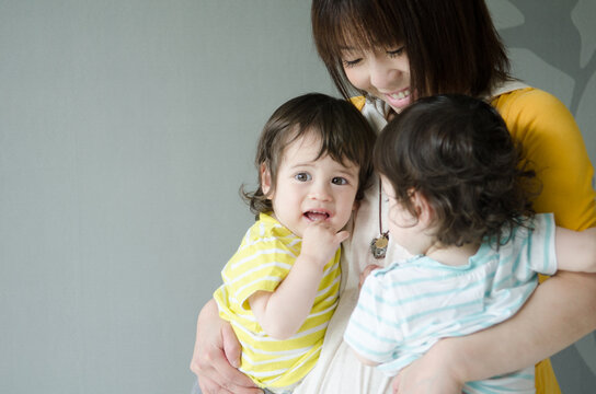 双子を抱っこする女性