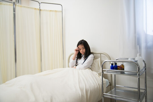 保健室のベッドにいる具合の悪そうな小学生の女の子