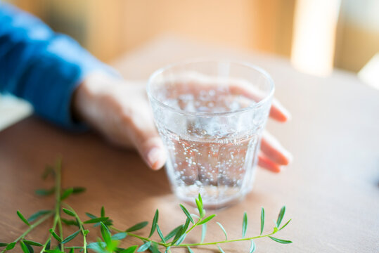 炭酸水の入ったグラスと女性の手元