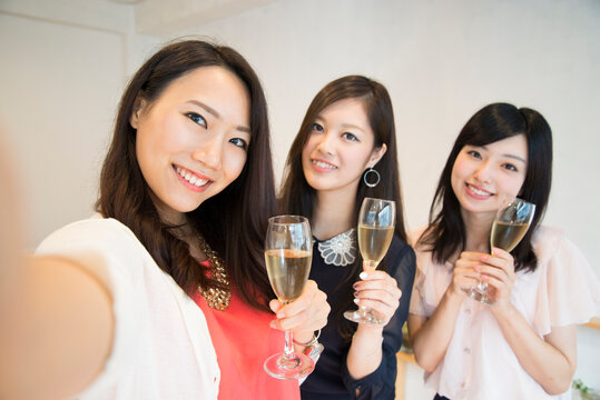 シャンパンを持って自撮りをしている女性たち