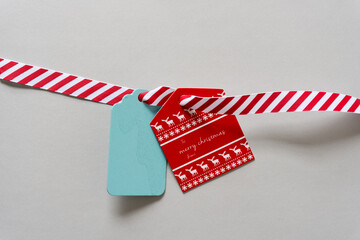 retro christmas gift tag with red and white ribbon arranged with a blank blue tag
