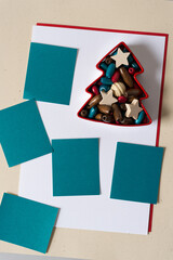 tree form christmas cookie cutter full of wooden beads and stars with blank paper squares