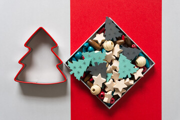 box with beads and cookie cutter on gray and red paper