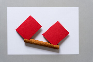two red paper squares and cinnamon stick