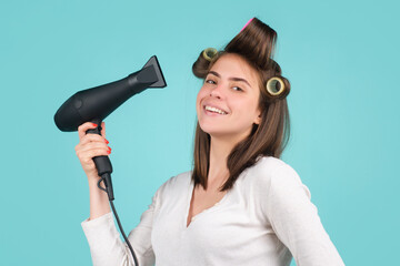 Young woman with hair dryer. Beautiful girl with straight hair drying hair with professional hairdryer.