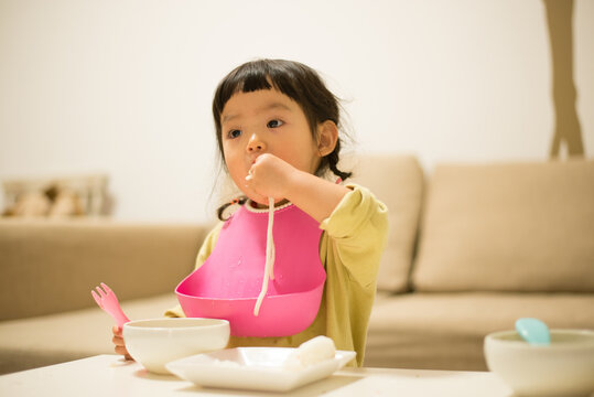家でうどんを食べている女の子