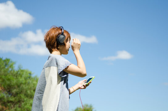 ヘッドフォンで音楽を聴いている女性
