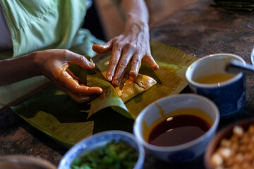 Close up of hands preparing hallaca or tamale. Traditional food concept