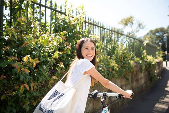 自転車を引いて振り返っている女性