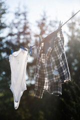 Dziecięce uprane ubrania na lince do prania na dworze - obrazy, fototapety, plakaty