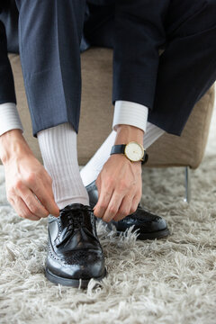 革靴の紐を結ぶ男性の足元
