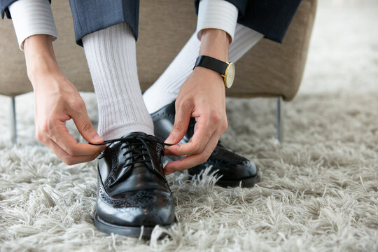 革靴の紐を結ぶ男性の足元