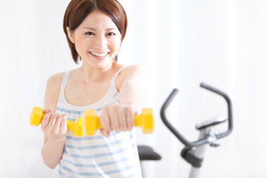 ダンベルを持ってエクササイズをする女性