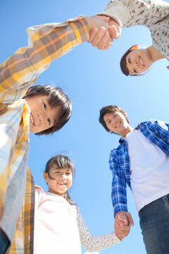 手をつないで輪になっている笑顔の家族