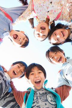 ランドセルを背負って輪になる笑顔の小学生6人